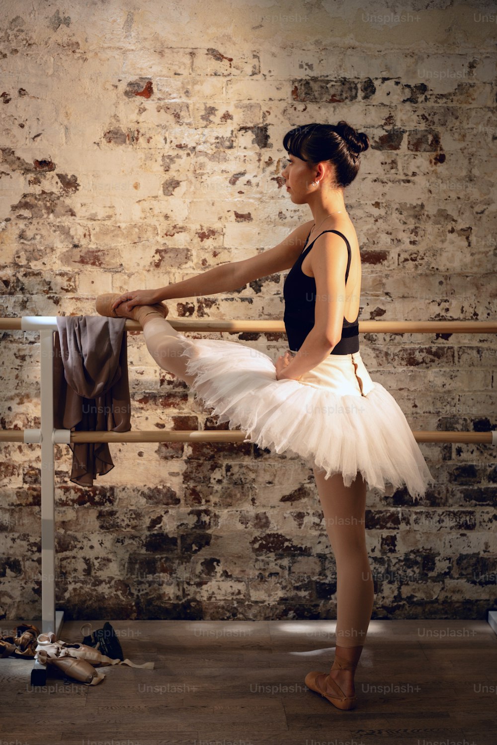a woman in a tutu is standing in front of a rail