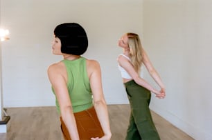 a woman standing in a room with another woman behind her