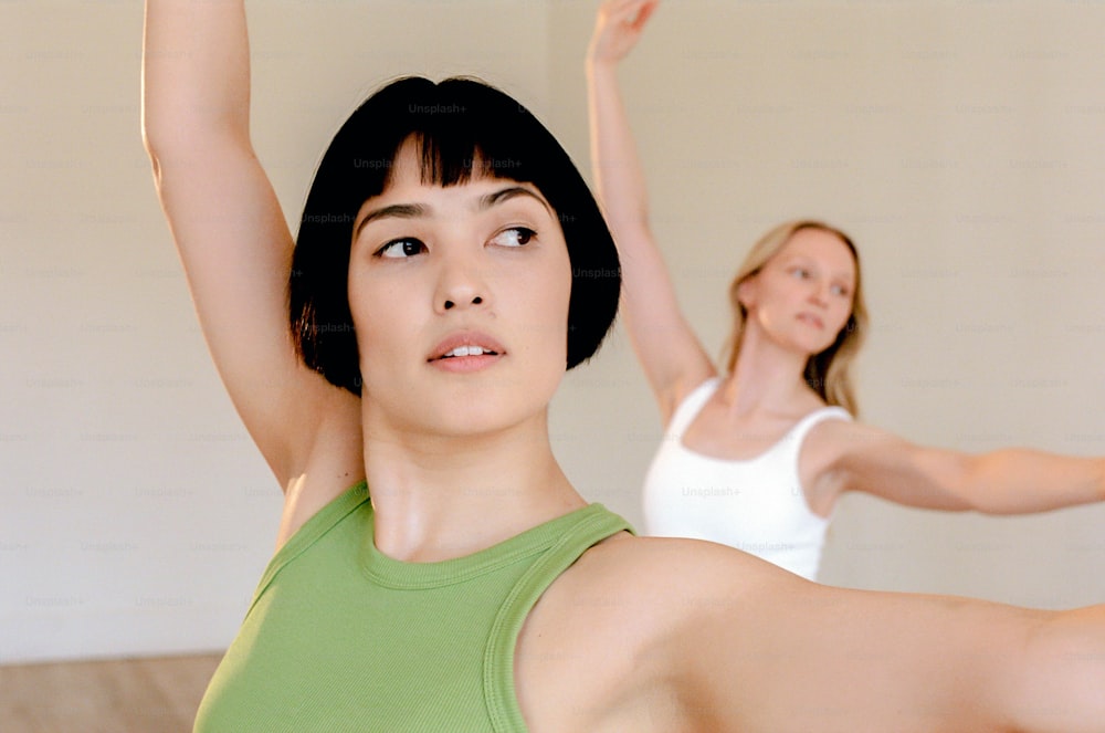 two women are doing yoga exercises in a room