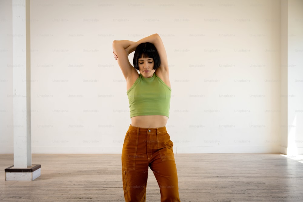 a woman in a green top and brown pants