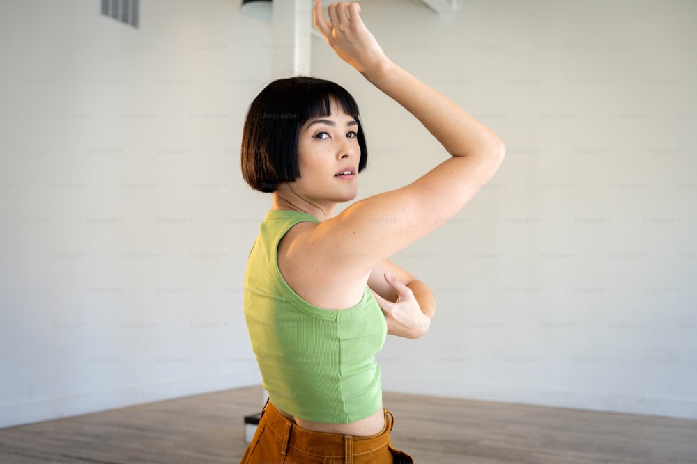 a woman in a green shirt is holding a white object