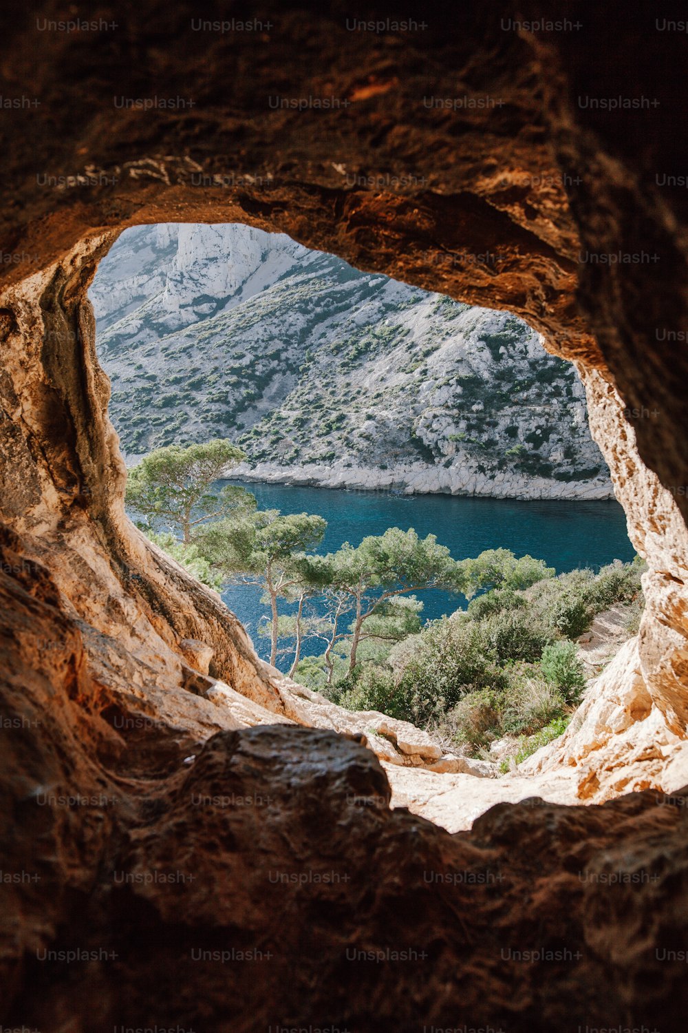 uma vista de um lago através de uma caverna