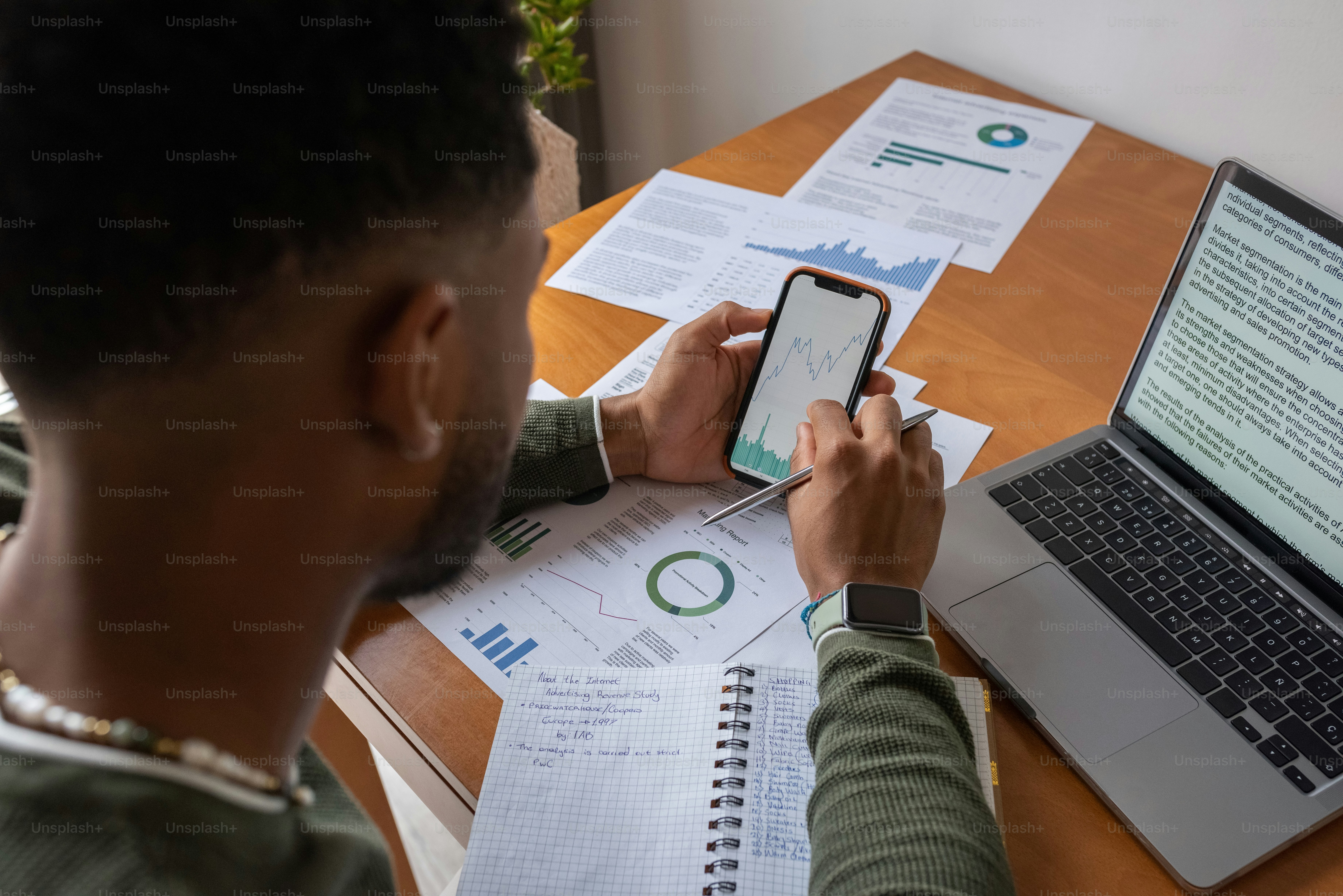 Un uomo seduto a una scrivania usando un telefono cellulare