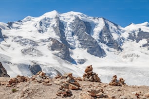 a pile of rocks sitting in front of a snow covered mountain