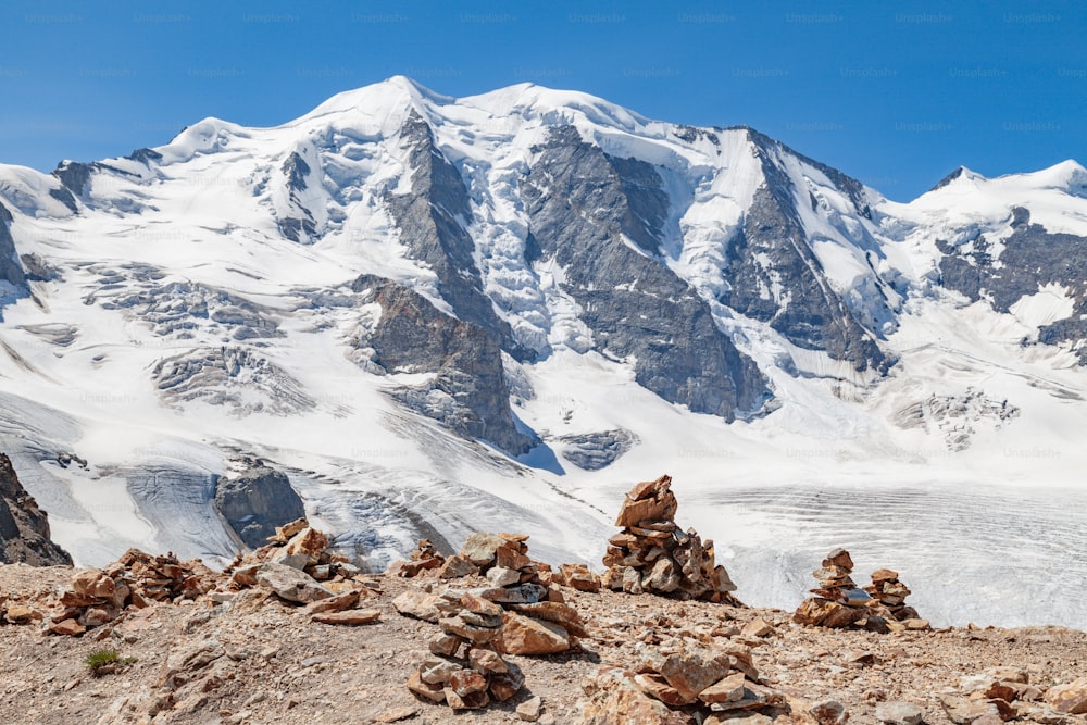 ein Steinhaufen, der vor einem schneebedeckten Berg sitzt