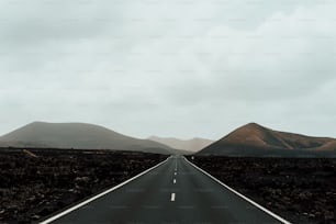 uma estrada vazia com montanhas ao fundo
