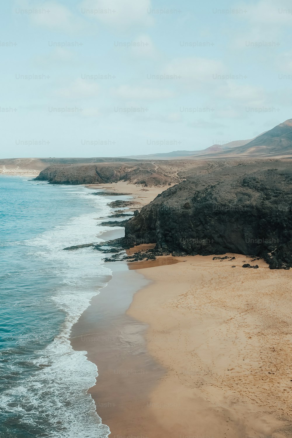 a sandy beach with waves coming in to the shore