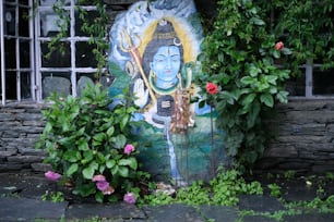 Ein Gemälde eines Buddhas, umgeben von Pflanzen und Blumen