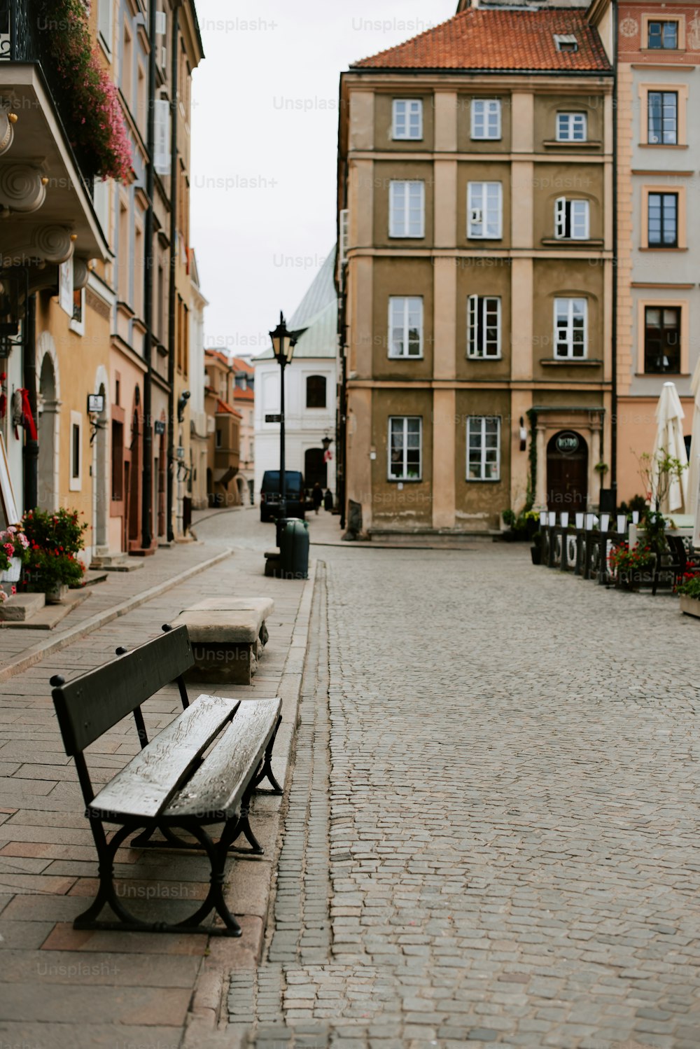 a wooden bench sitting on the side of a brick road