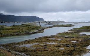 a large body of water with a bridge in the background