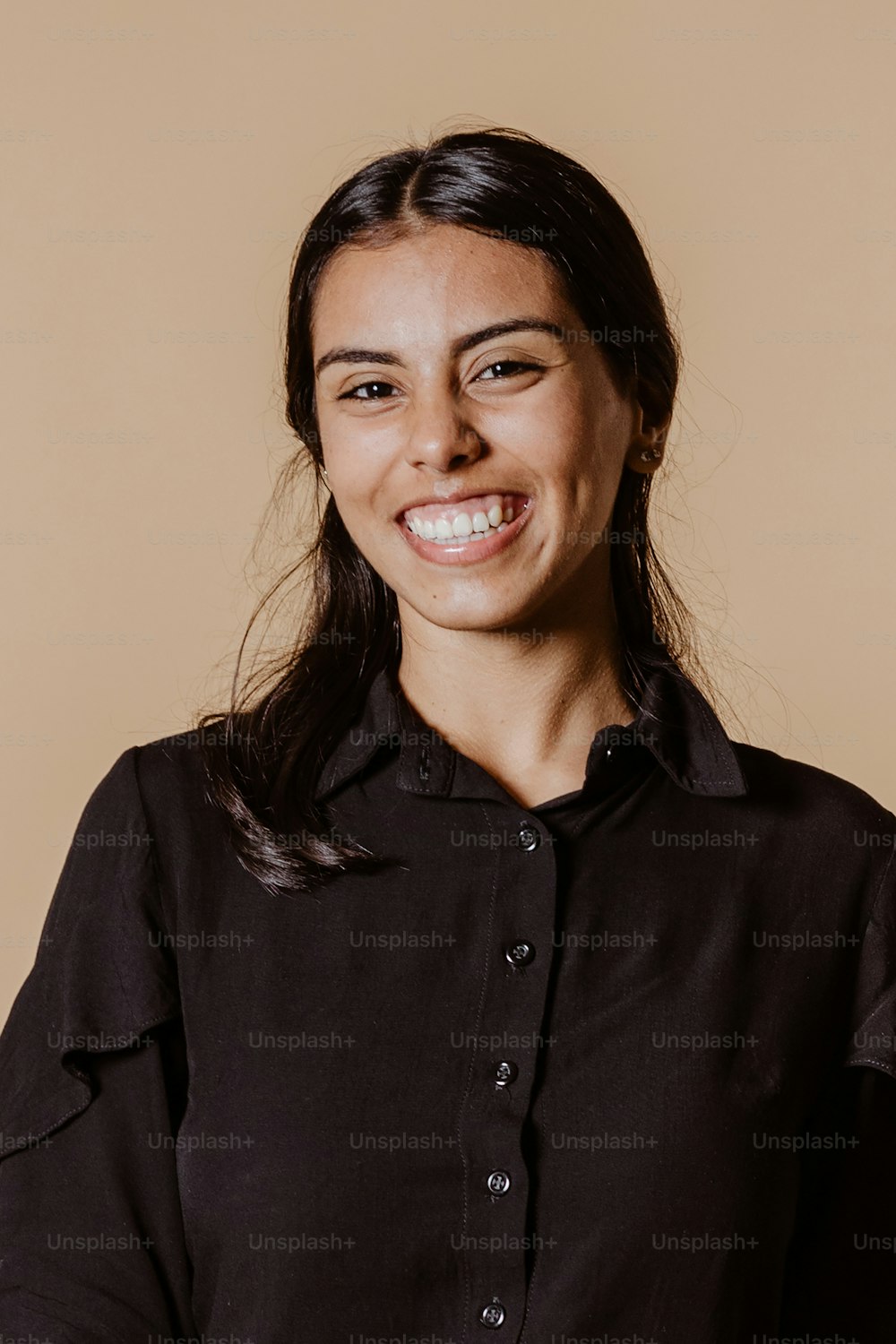 Une femme souriante en chemise noire