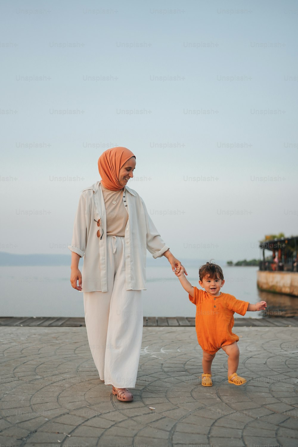 Una mujer sosteniendo la mano de un niño pequeño