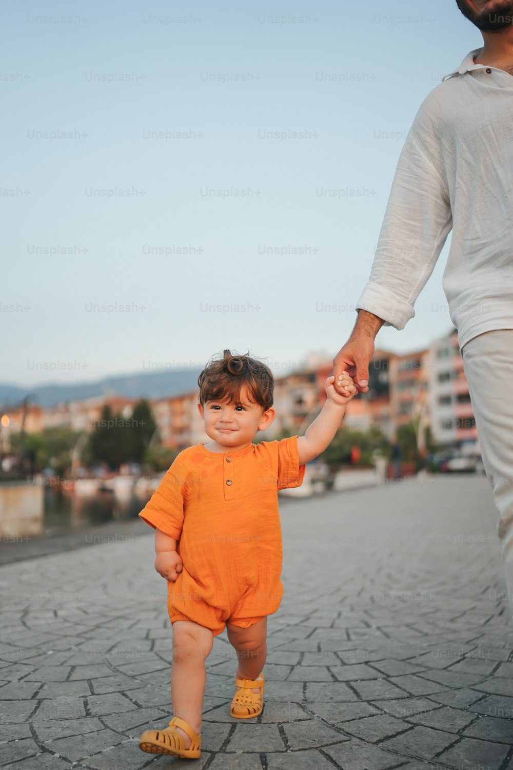 a man holding the hand of a small child