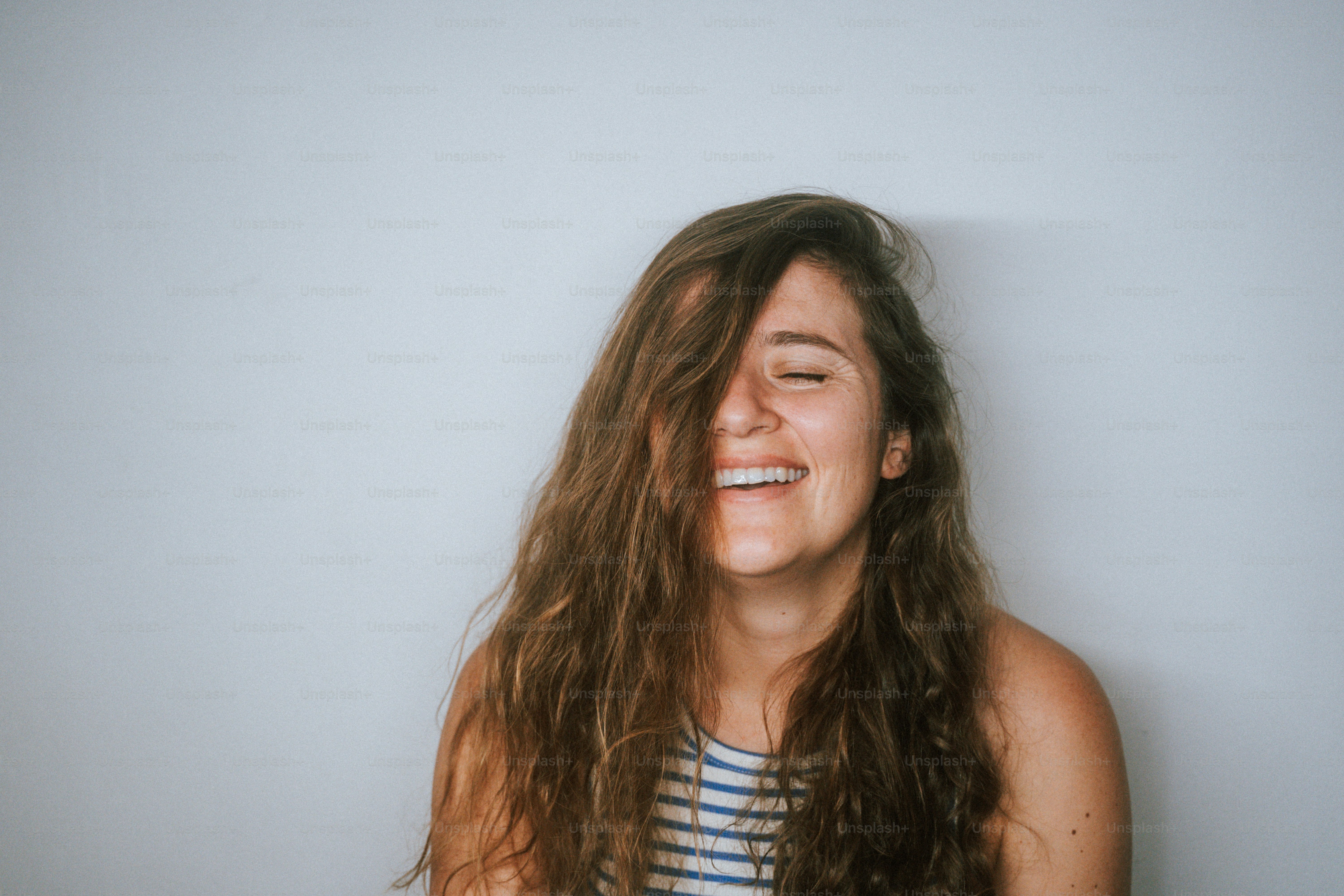 a woman with long hair smiling with her eyes closed