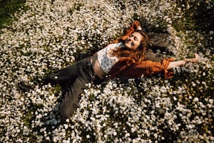 Una donna che posa in un campo di fiori bianchi
