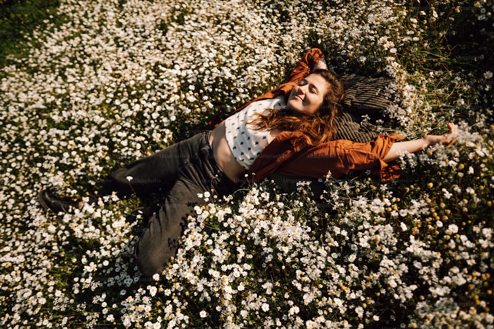 a woman laying in a field of white flowers