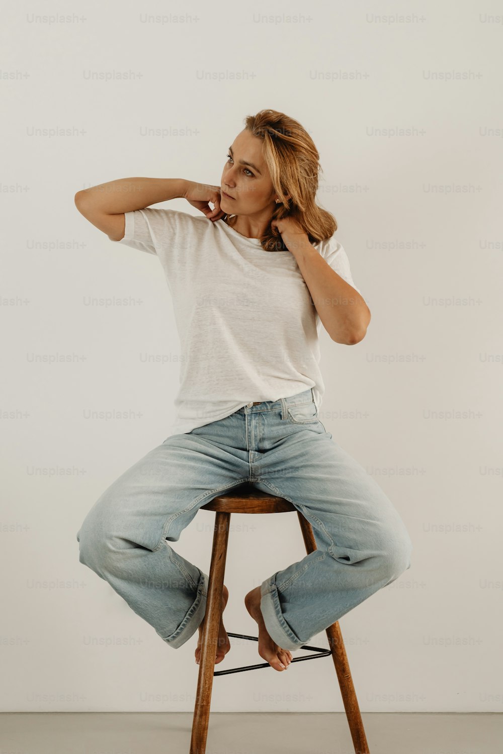 a woman sitting on top of a wooden stool