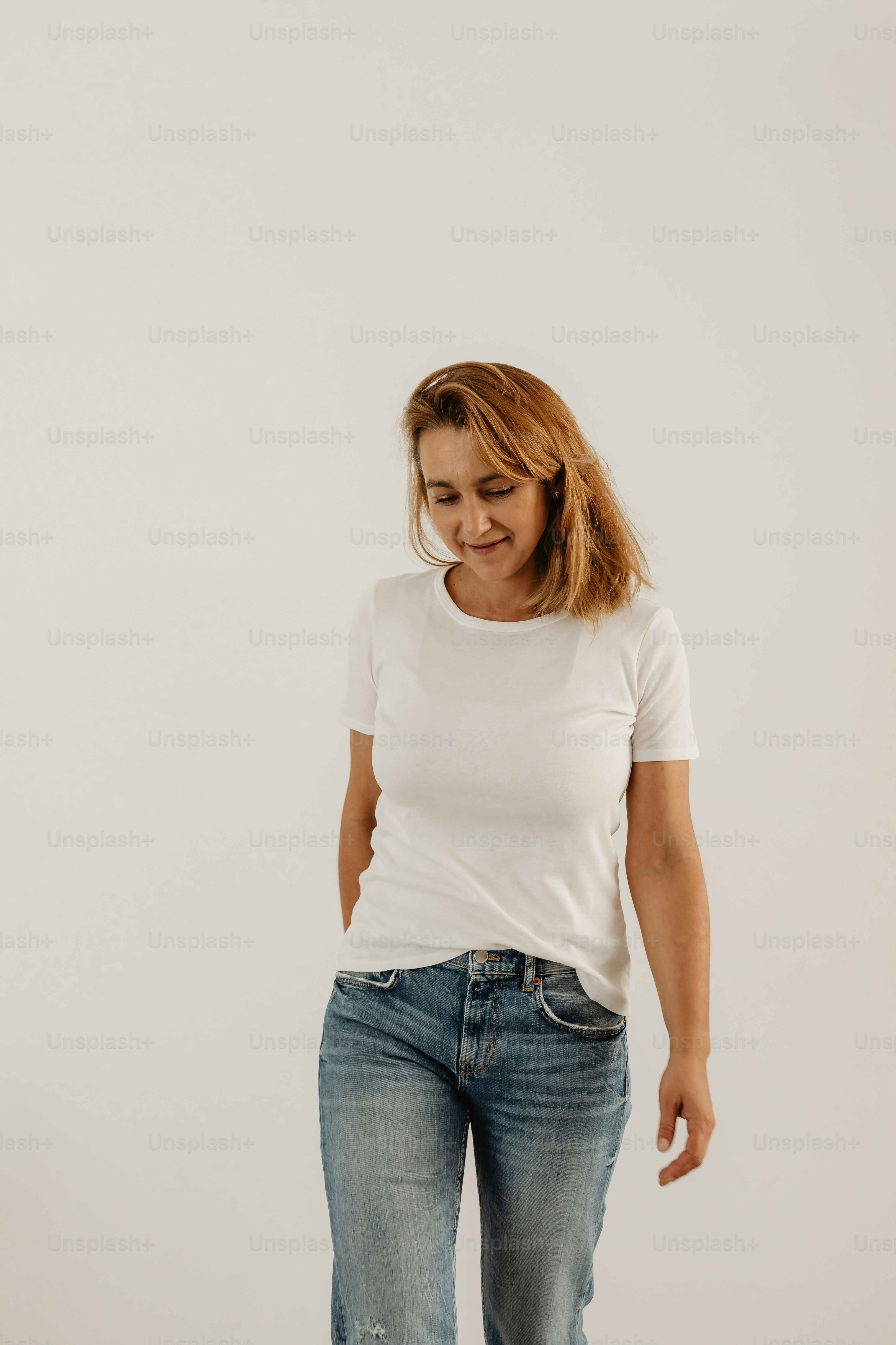 seorang wanita dengan kemeja putih dan jeans