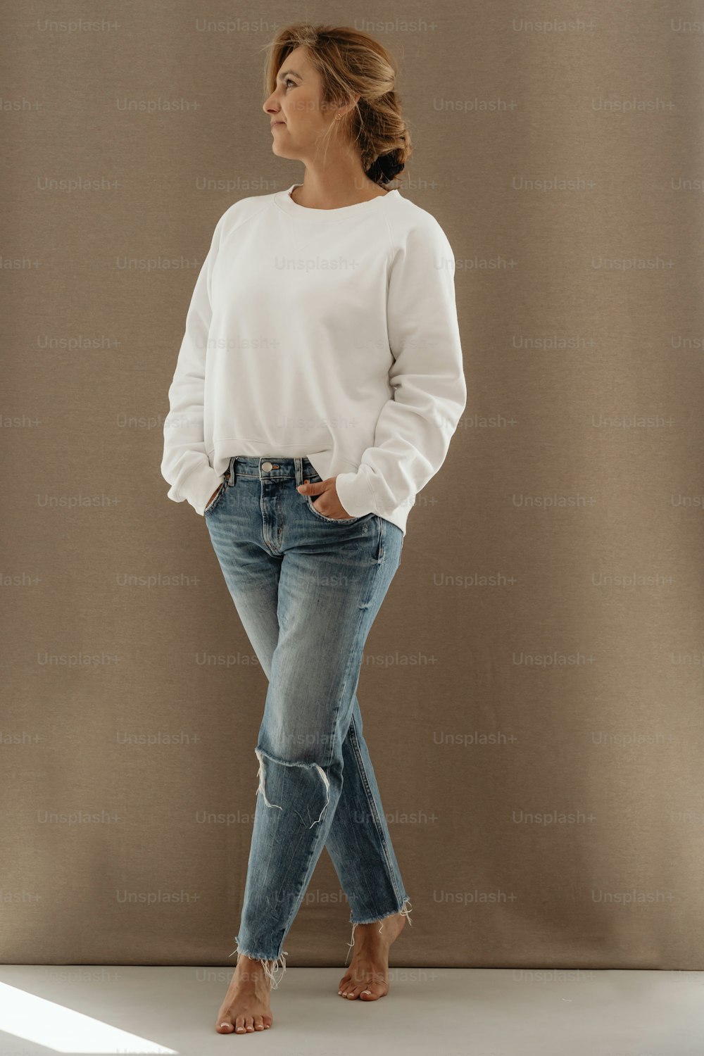 Una donna in camicia bianca e jeans