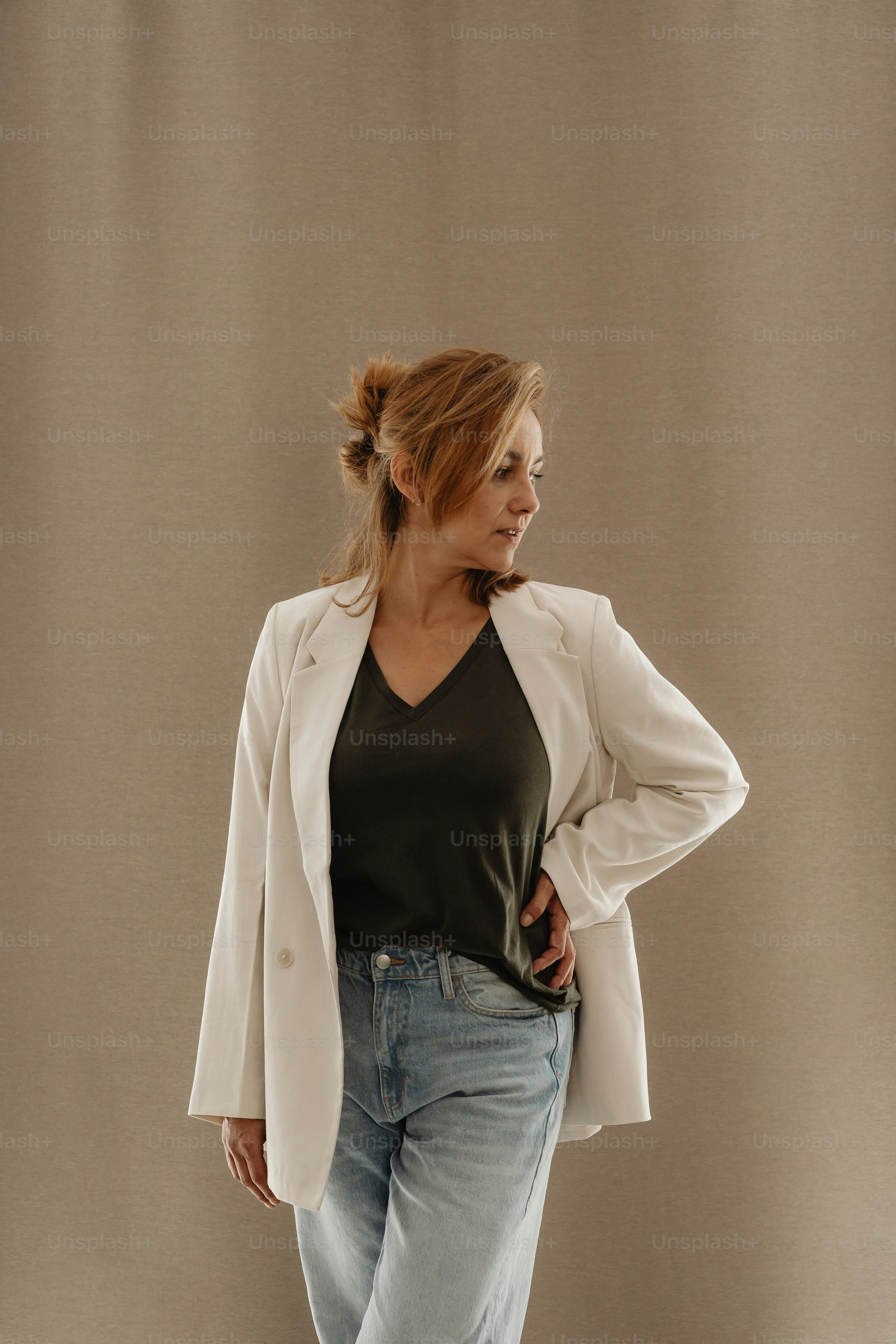 a woman in a black top and white blazer