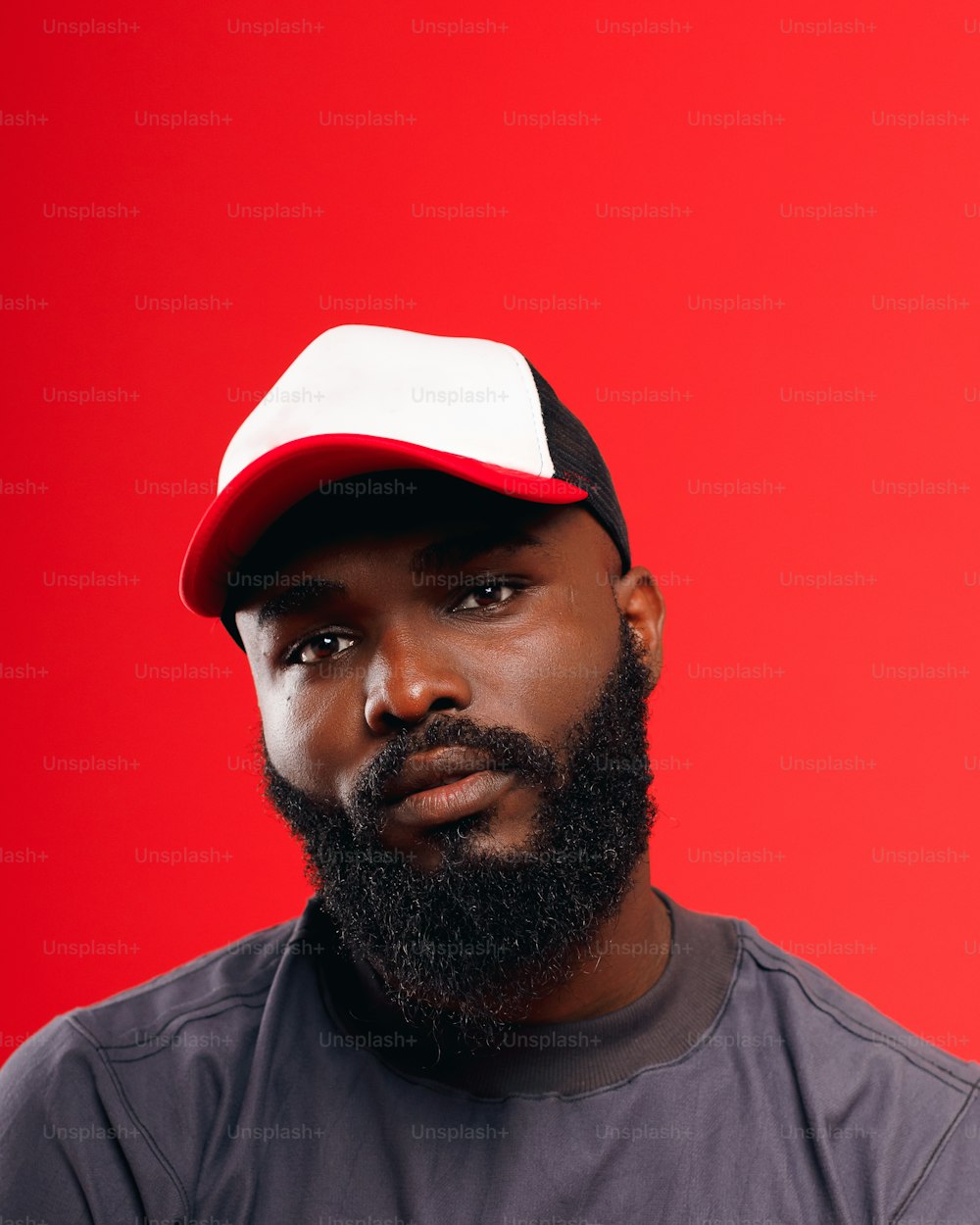 um homem com barba usando um chapéu vermelho e branco