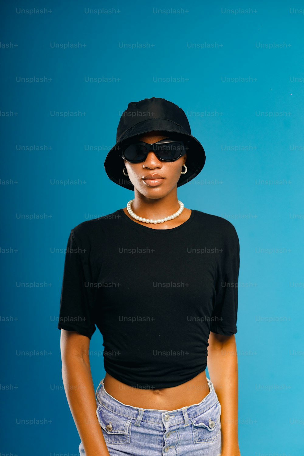 uma mulher usando um chapéu preto e óculos escuros