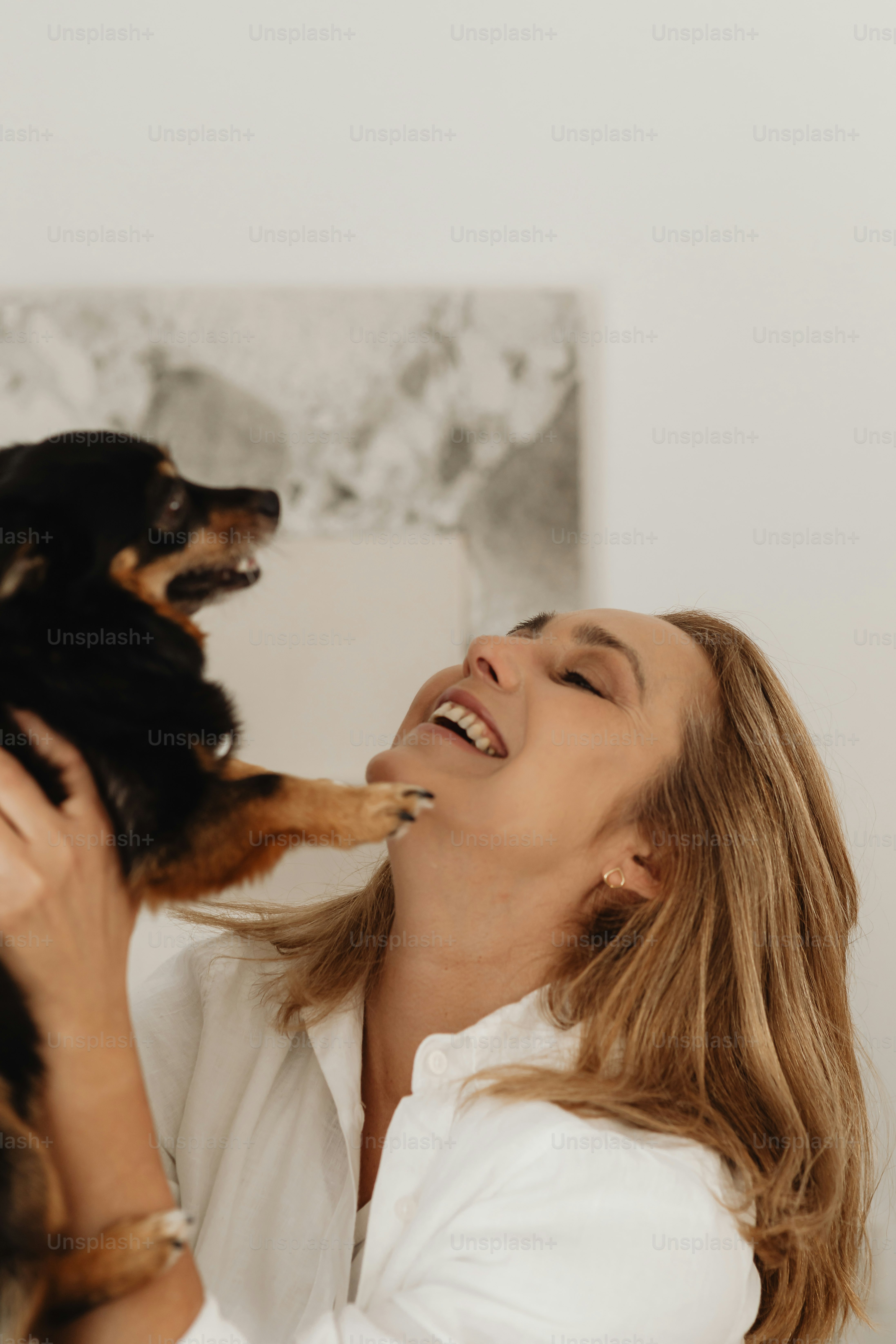 Una donna che tiene un cane fino al viso