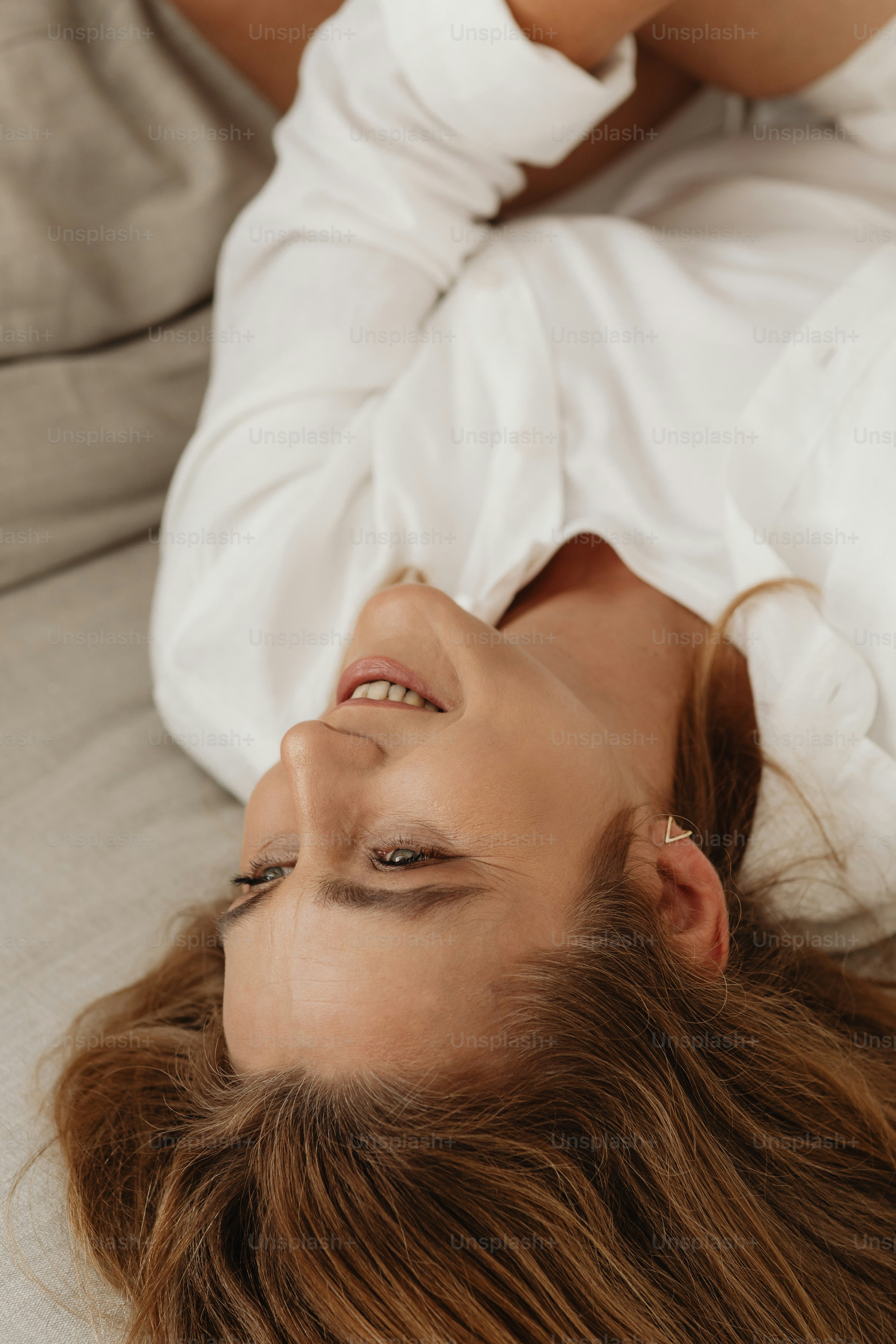 a woman laying on a bed with her eyes closed