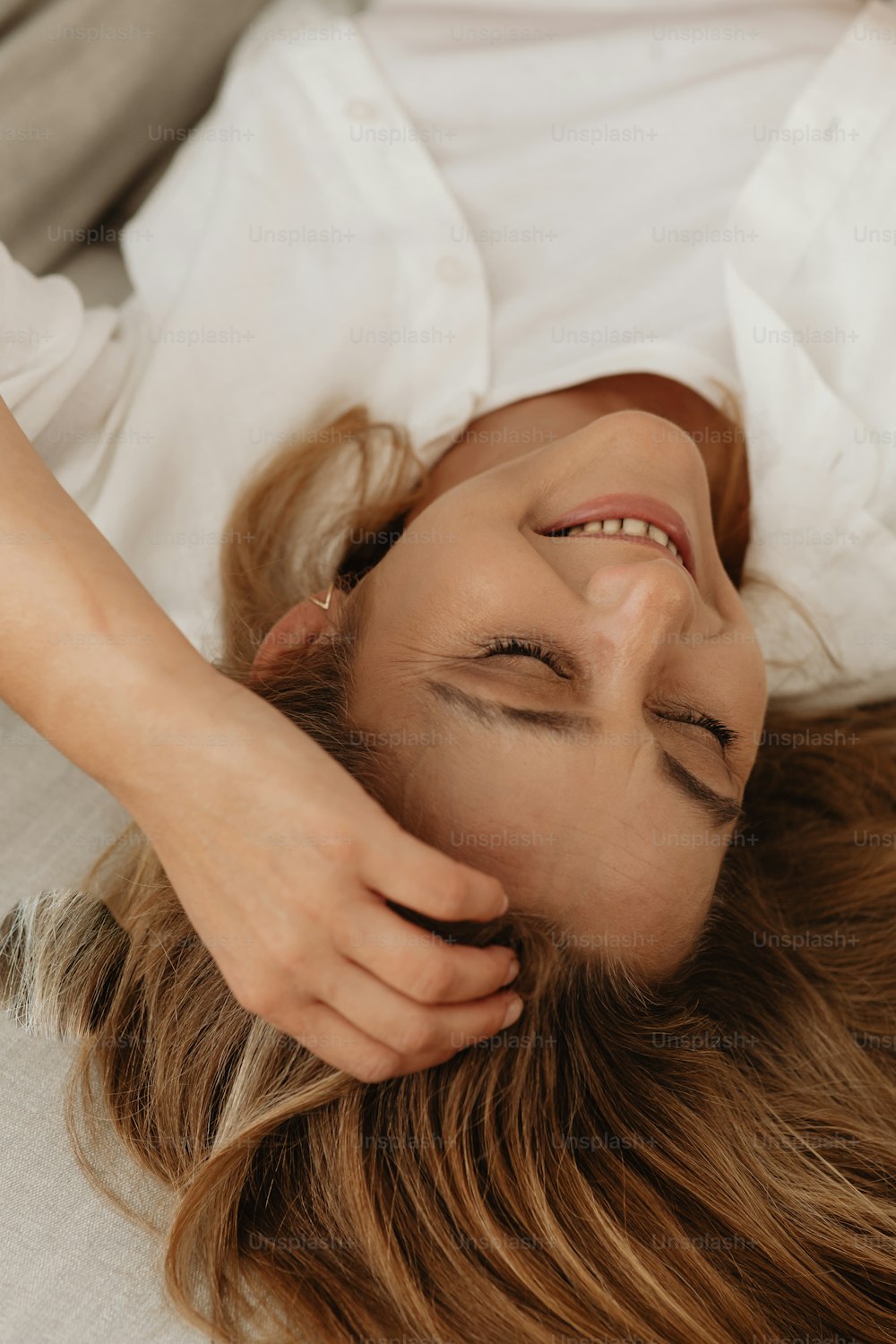 Una mujer acostada en una cama con los ojos cerrados