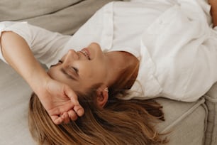 a woman laying on a couch with her eyes closed