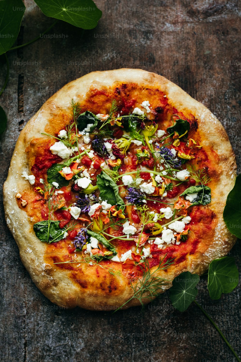 une pizza garnie de beaucoup de légumes et de fromage