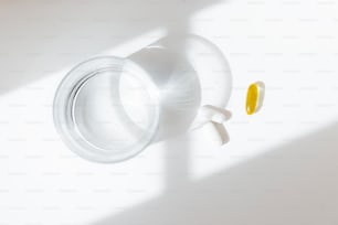 una bottiglia con un tappo giallo seduto su una superficie bianca