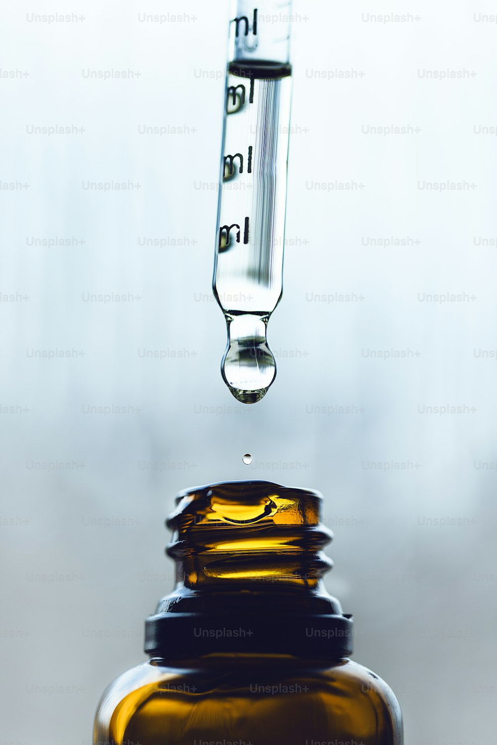 um conta-gotas cheio de um líquido sentado em cima de uma garrafa