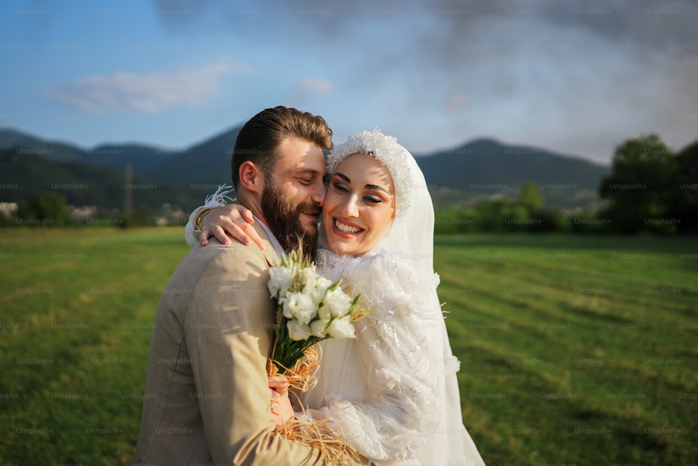 Una novia y un novio abrazándose en un campo