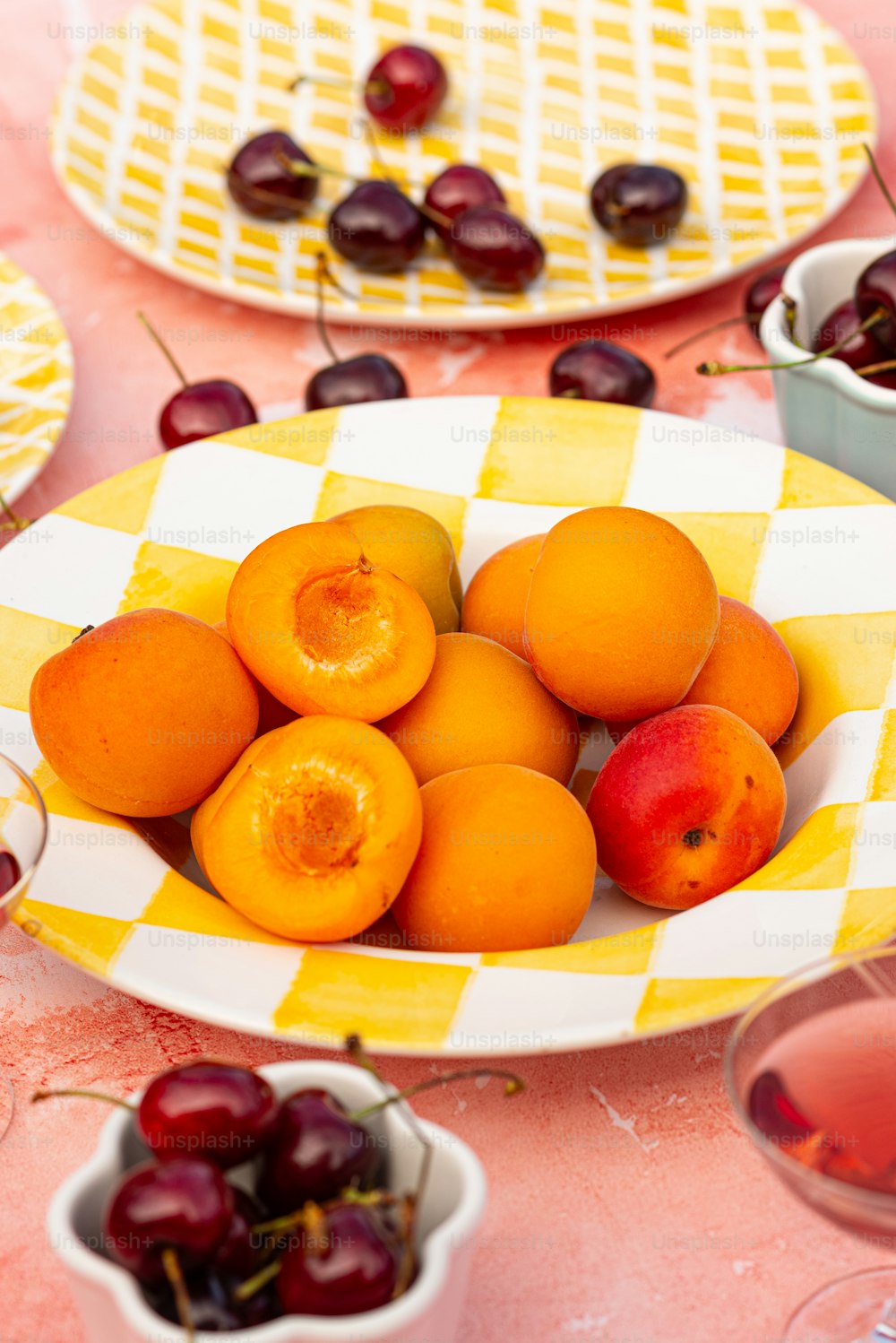 uma tigela de cerejas e um prato de cerejas sobre uma mesa