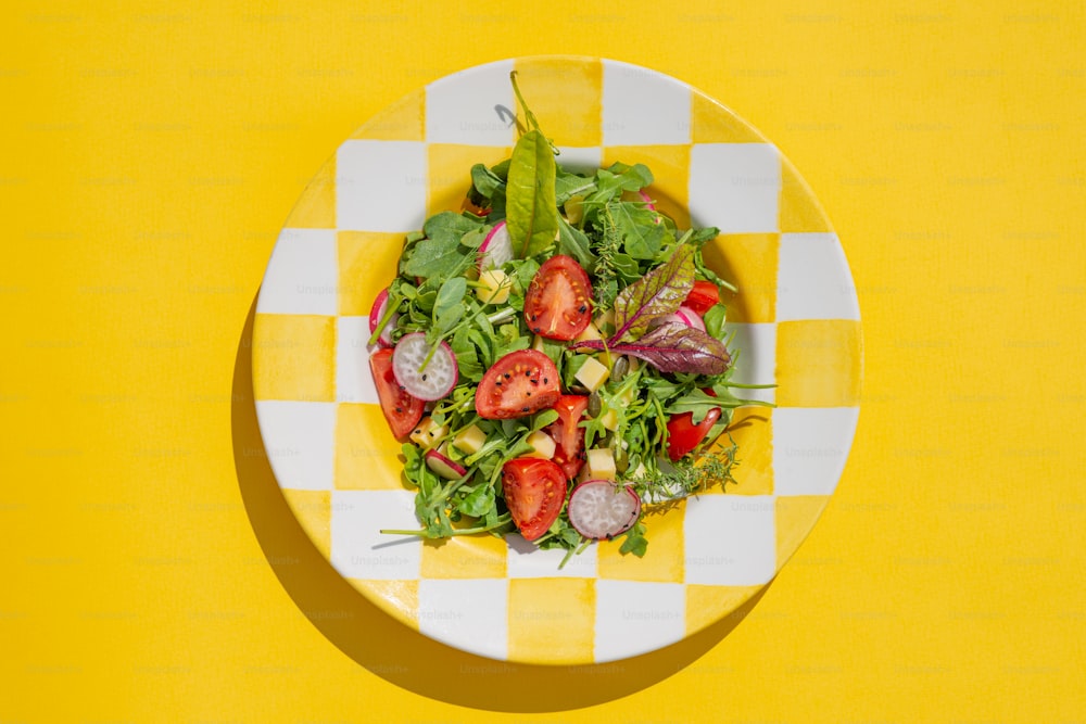 um prato quadriculado amarelo e branco com uma salada