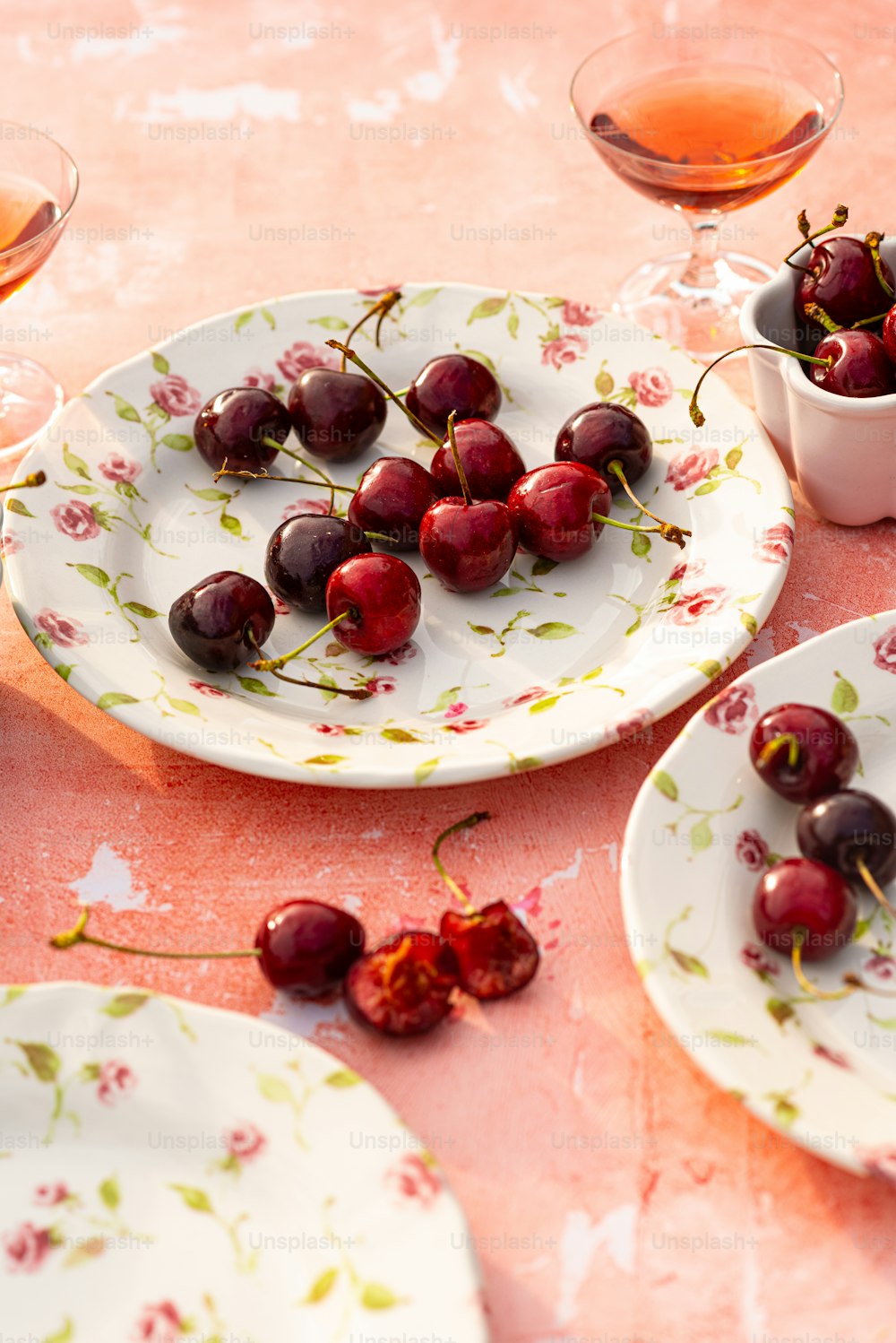 uma mesa coberta com pratos e tigelas cheias de cerejas