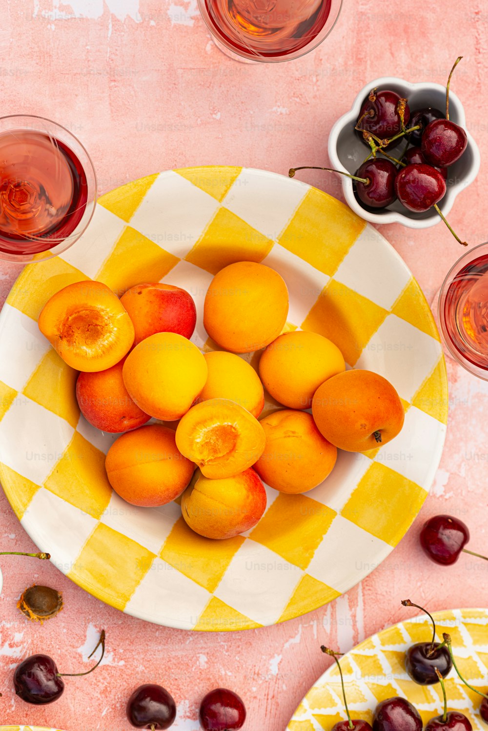 uma tigela de cerejas e um prato de cerejas sobre uma mesa