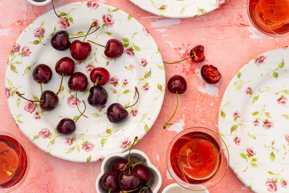 una mesa cubierta con platos y cuencos llenos de cerezas