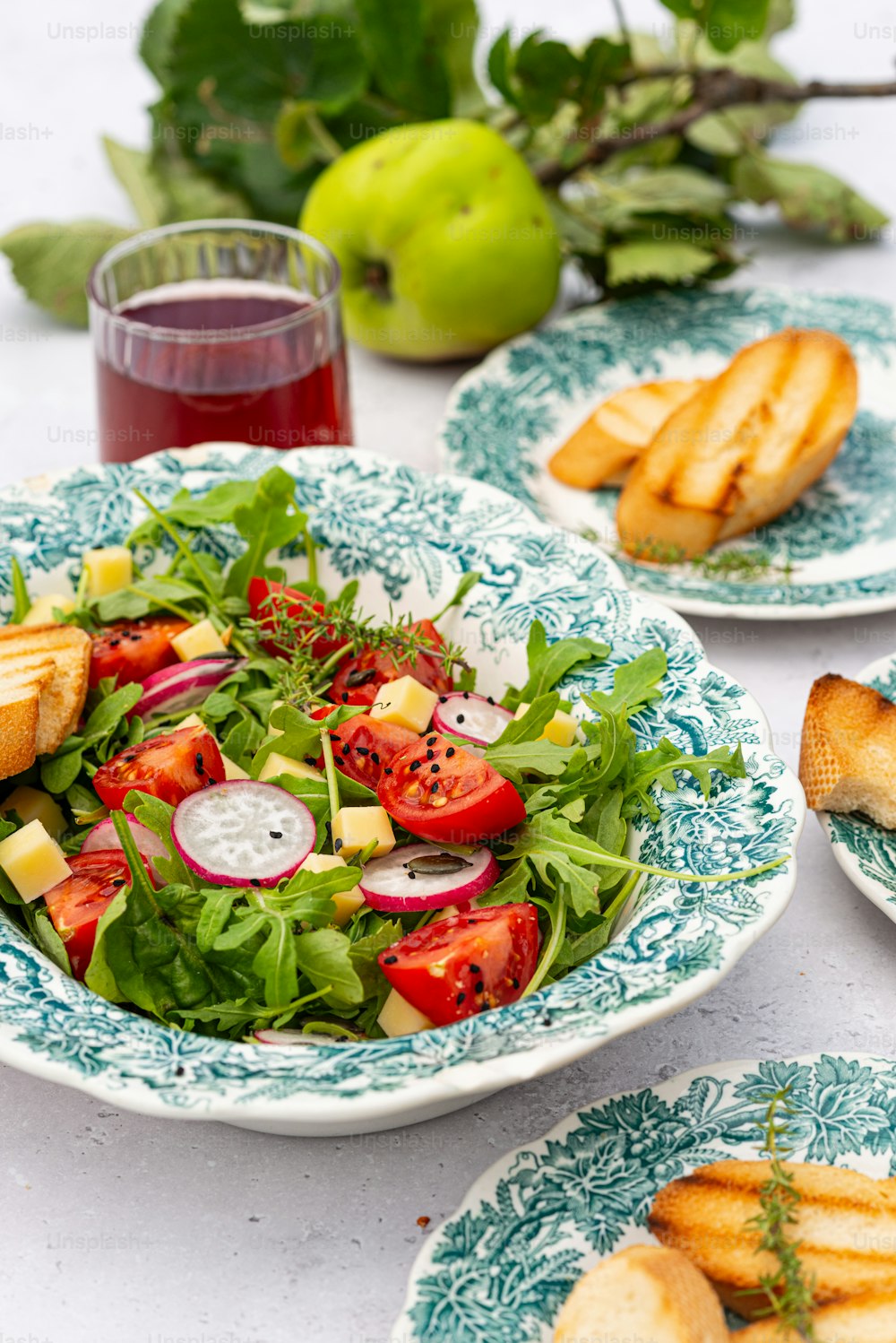 a table topped with plates of food and a glass of juice