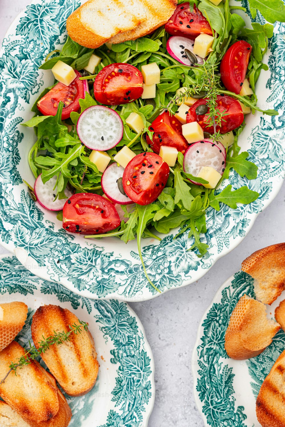 uma salada com tomates, pepinos, queijo e pão
