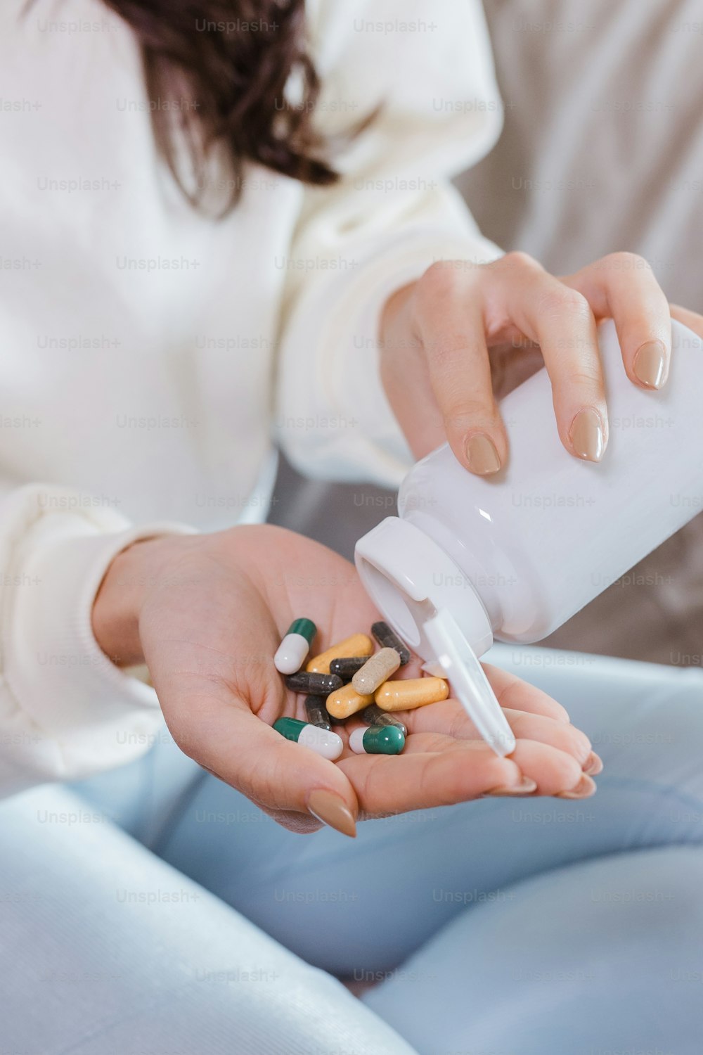 Una mujer sosteniendo un frasco de pastillas en sus manos