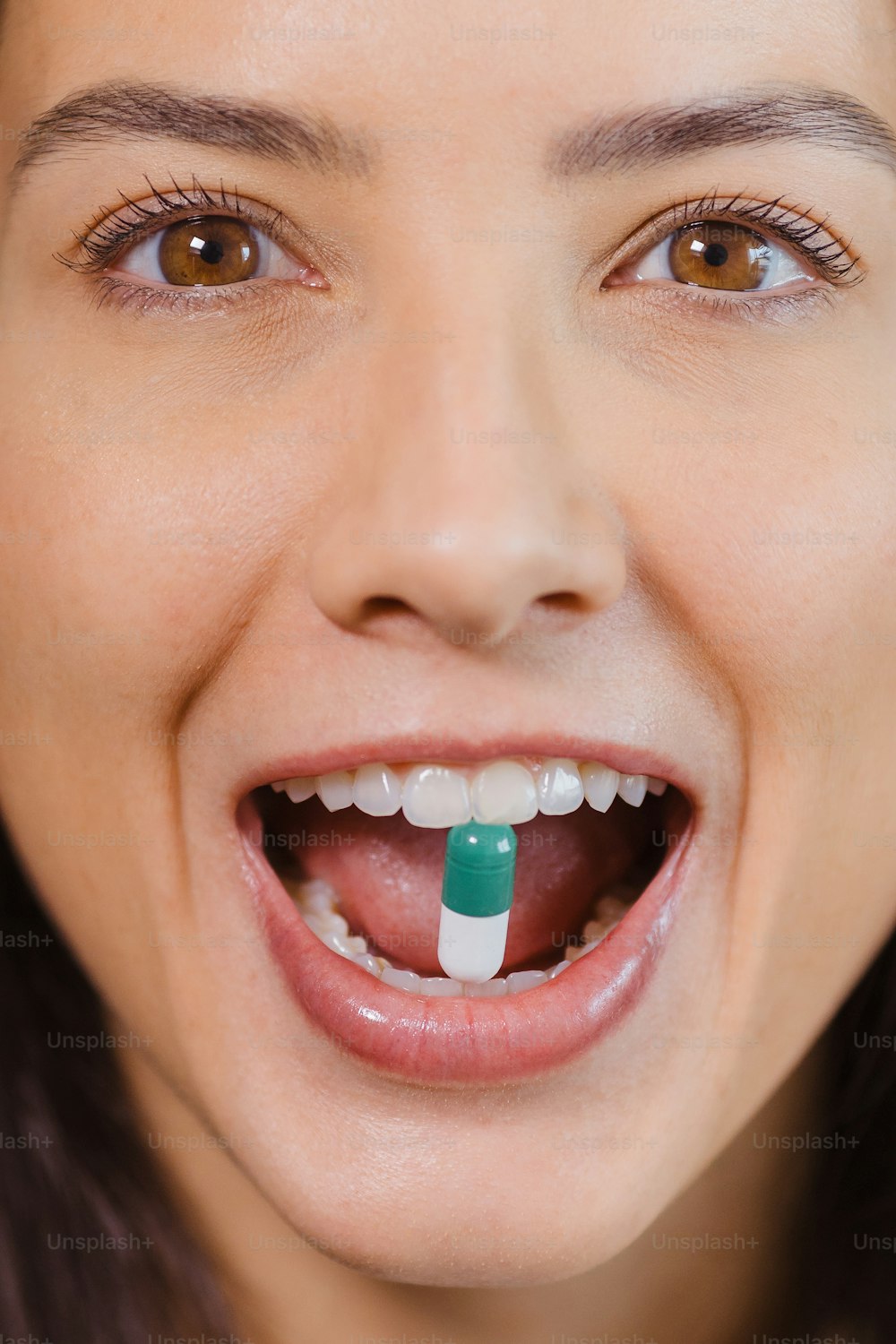 Una mujer con un cepillo de dientes verde y blanco en la boca