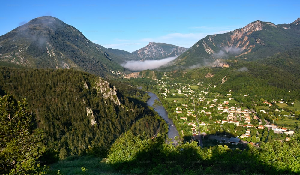 a valley surrounded by mountains with a river running through it