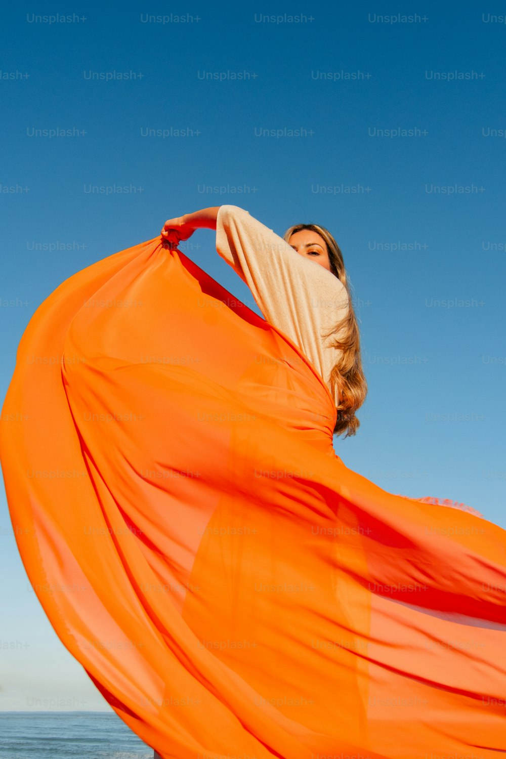 a woman in an orange dress on the beach