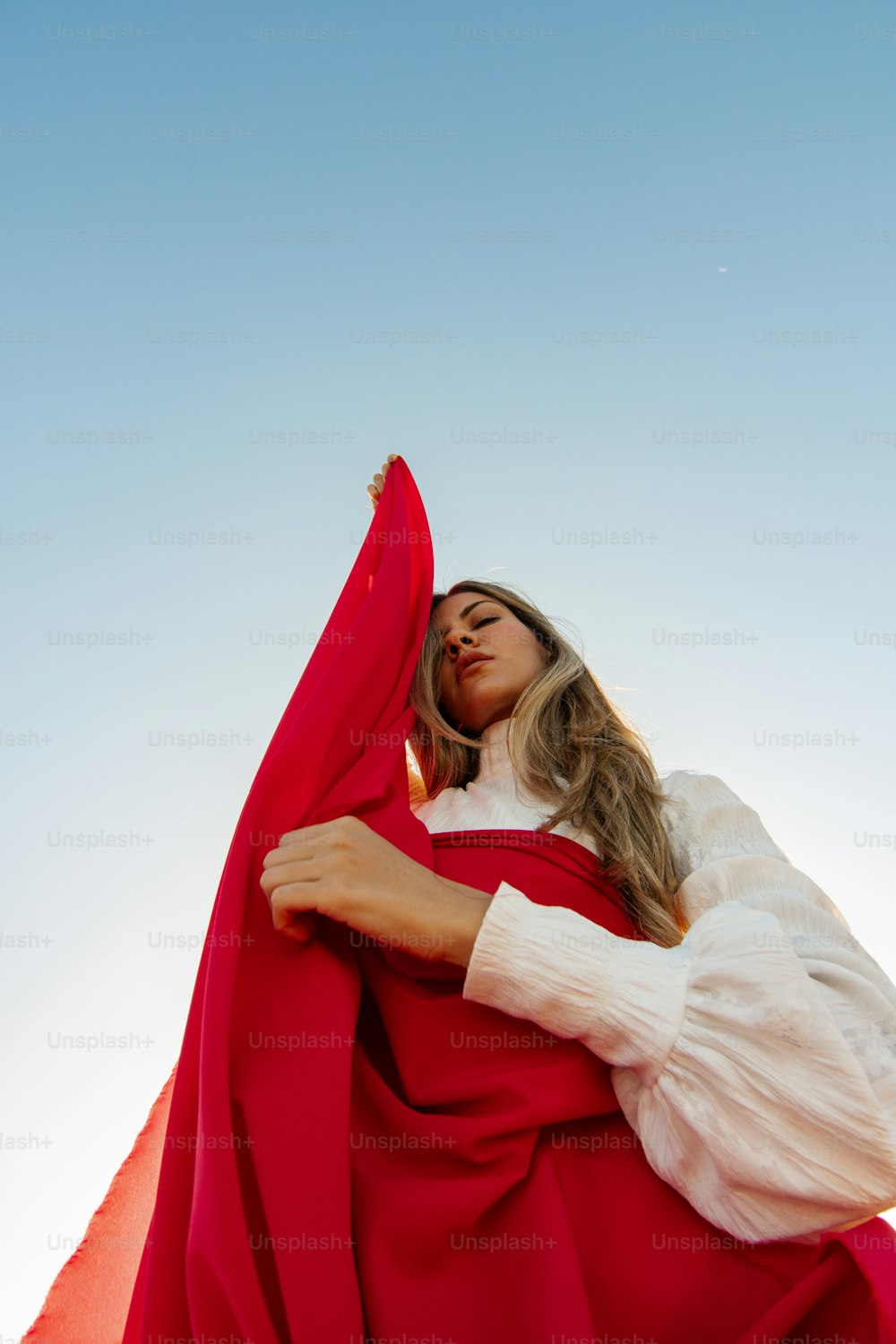 Uma mulher com um manto vermelho está posando para uma foto