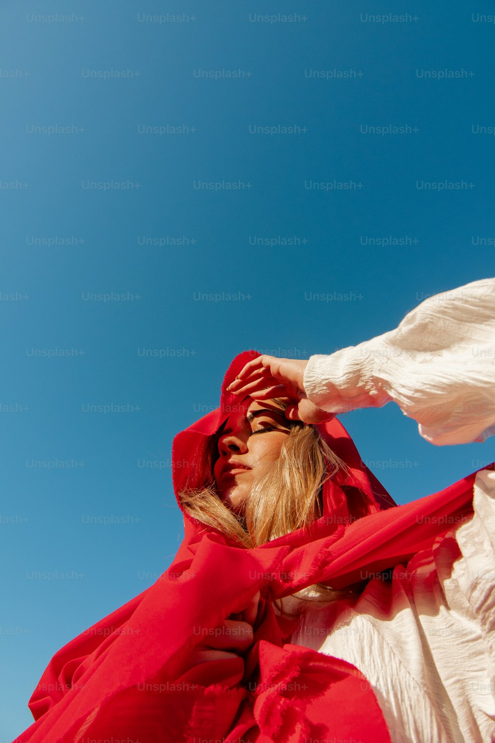 Una mujer con un vestido rojo y blanco y un cielo azul