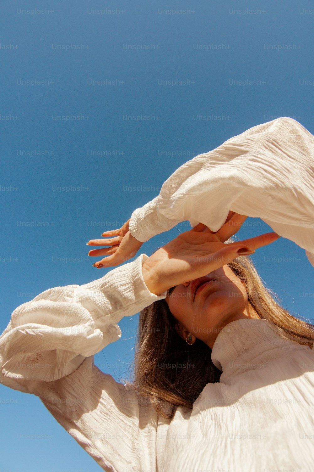 a woman in a white shirt is holding her hands up