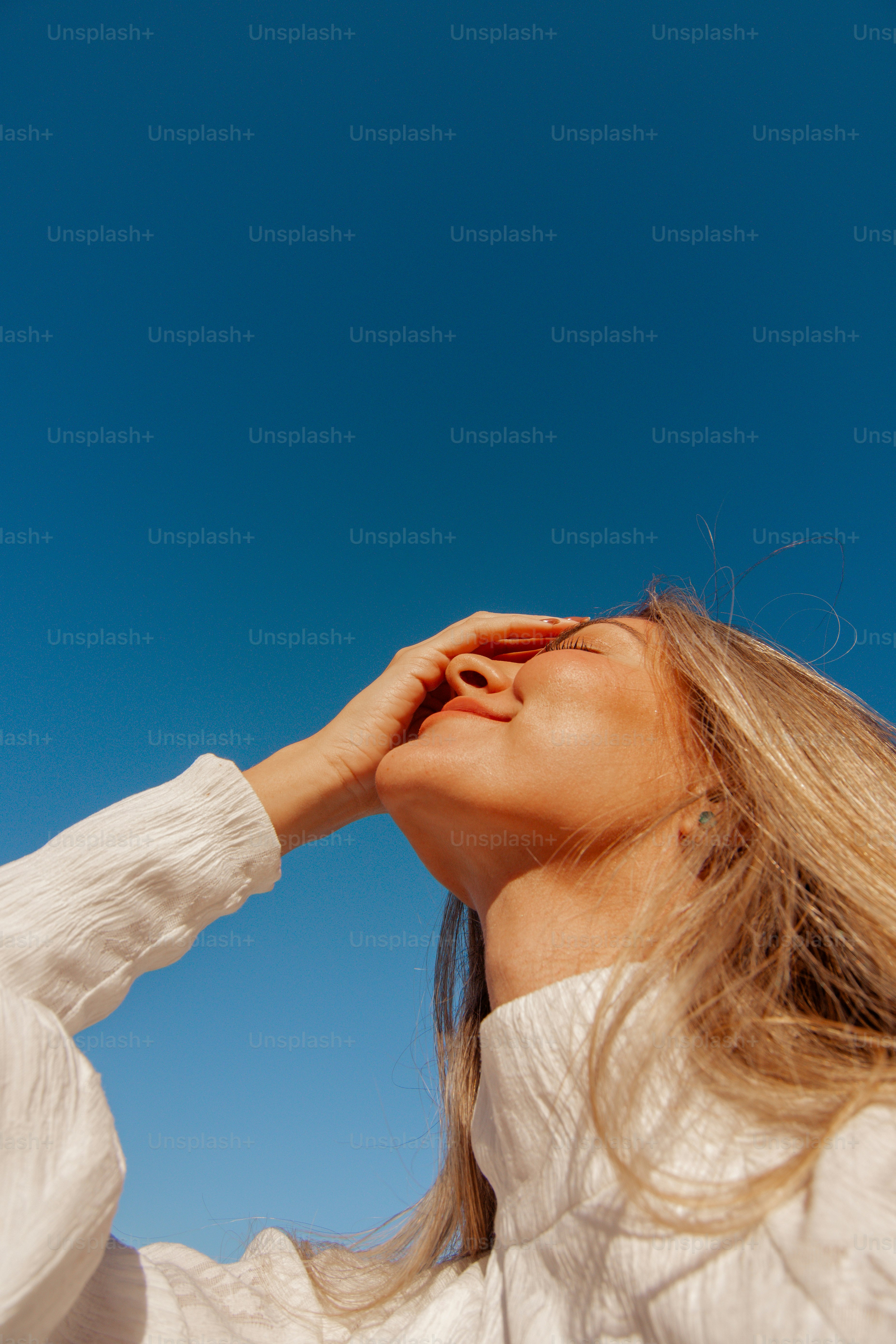 a woman in a white shirt is flying a kite