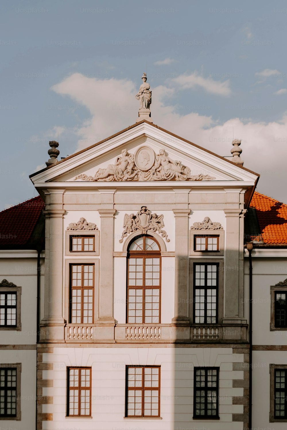 a large white building with a clock on the top of it